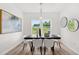 Elegant dining room with modern light fixture, large window, and decorative wall art at 210 Sharon Ln, Loganville, GA 30052