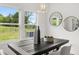 Bright dining area featuring large window, sleek black table, and stylish round mirrors at 210 Sharon Ln, Loganville, GA 30052