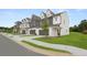 Street view of new townhomes with two-car garages, landscaping, and craftsman-style architectural details at 210 Sharon Ln, Loganville, GA 30052