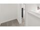 Hallway corner with soft gray carpet and a glimpse into a bedroom with neutral decor at 210 Sharon Ln, Loganville, GA 30052