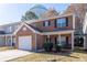Red brick two-story home featuring a well maintained front yard and an attached one car garage at 538 Shadowmoore Dr, Riverdale, GA 30274