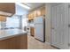 Bright kitchen featuring tile floors, wooden cabinets, and white appliances at 538 Shadowmoore Dr, Riverdale, GA 30274