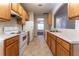 Bright kitchen featuring wood cabinets, white appliances, and tile flooring at 538 Shadowmoore Dr, Riverdale, GA 30274