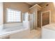 Main bathroom featuring a jacuzzi tub, glass enclosed shower, and double sinks at 538 Shadowmoore Dr, Riverdale, GA 30274