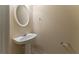 Simple powder room featuring a pedestal sink, an oval mirror, and neutral wall color at 538 Shadowmoore Dr, Riverdale, GA 30274