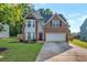 Charming two-story brick home features an attached two-car garage and a well-manicured front lawn at 575 Chapel Walk Ln, Lawrenceville, GA 30045