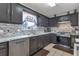Modern kitchen with stainless steel appliances, stone counter tops, and grey cabinetry at 575 Chapel Walk Ln, Lawrenceville, GA 30045