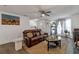 Cozy living room with a brown leather sofa, decorated with plants and a modern artwork at 575 Chapel Walk Ln, Lawrenceville, GA 30045