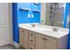 Bright blue bathroom featuring a double sink vanity with drawers and sleek fixtures and hardware at 230 Ryan Ln, Covington, GA 30014