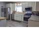 Modern kitchen with stainless steel appliances, white cabinets, and an eat-in island at 230 Ryan Ln, Covington, GA 30014