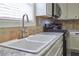 Close-up of the kitchen sink featuring a modern faucet, countertop, and tiled backsplash at 230 Ryan Ln, Covington, GA 30014
