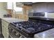 Featuring a stainless steel kitchen stove, countertop, and tiled backsplash at 230 Ryan Ln, Covington, GA 30014