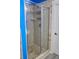Tiled walk-in shower features glass doors, a shower head, and shelving in a bright blue bathroom at 230 Ryan Ln, Covington, GA 30014