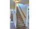 Carpeted staircase with wooden handrail and white risers leads upstairs; open door reveals bedroom at 230 Ryan Ln, Covington, GA 30014