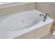 Inviting bathtub with jets surrounded by tile, perfect for relaxation and unwinding after a long day at 230 Ryan Ln, Covington, GA 30014