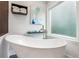 Bright bathroom featuring a standalone tub, modern fixtures, a frosted window, and modern decor at 2356 Defoors Ferry Nw Rd, Atlanta, GA 30318
