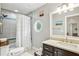 Bathroom featuring a shower, vanity, white tiling, and octagonal window for natural light at 2356 Defoors Ferry Nw Rd, Atlanta, GA 30318