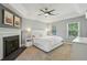 Bedroom featuring a fireplace, tray ceiling with fan, and neutral tones for a serene ambiance at 2356 Defoors Ferry Nw Rd, Atlanta, GA 30318