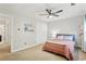 Neutral bedroom with a ceiling fan, plush carpet, window, double closet, and minimal furniture at 2356 Defoors Ferry Nw Rd, Atlanta, GA 30318