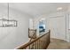 Hallway with views of bedrooms, doors, wooden railing, and modern chandelier at 2356 Defoors Ferry Nw Rd, Atlanta, GA 30318