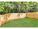 Backyard featuring newly seeded grass and a privacy fence, shaded by mature trees at 2849 Windsor Forrest Ct, Atlanta, GA 30349