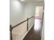 Hallway features a wooden banister, wooden floor, and white walls at 2849 Windsor Forrest Ct, Atlanta, GA 30349