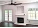 Bright living room featuring a fireplace, ceiling fan, and french doors to the backyard at 2849 Windsor Forrest Ct, Atlanta, GA 30349