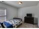 Simple bedroom with a single bed, a dark dresser, and a window for natural light at 4619 Sweetwater Ave, Powder Springs, GA 30127