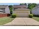 View of home with a driveway leading to an attached garage and some bushes nearby at 4619 Sweetwater Ave, Powder Springs, GA 30127
