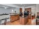 Open concept kitchen featuring an island, hardwood floors, and views into the living area at 4619 Sweetwater Ave, Powder Springs, GA 30127