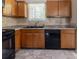 Well-equipped kitchen with wood cabinetry, black appliances, and a sink overlooking a window at 5339 Biffle Downs Rd, Stone Mountain, GA 30088