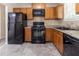 Functional kitchen featuring black appliances, wood cabinets, and durable countertops for everyday cooking at 5339 Biffle Downs Rd, Stone Mountain, GA 30088