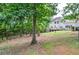 Wooded backyard with mature trees, landscaping, and deck, offering privacy and a natural setting at 6450 Oak Valley Dr, Cumming, GA 30040