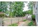 Charming backyard with a wooden deck, quaint picket fence, and lush greenery and trees at 6450 Oak Valley Dr, Cumming, GA 30040