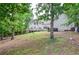 Large backyard with mature trees, landscaping, and deck, offering privacy and a natural setting at 6450 Oak Valley Dr, Cumming, GA 30040
