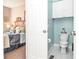 Bathroom with toilet, overhead storage, and neutral colored walls adjacent to bedroom with queen bed at 6450 Oak Valley Dr, Cumming, GA 30040
