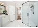 Bathroom featuring white tile floor and shower with glass doors, black hardware, and bright vanity at 6450 Oak Valley Dr, Cumming, GA 30040