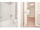 Clean white bathroom with shower-tub combination and a doorway view of a bedroom at 6450 Oak Valley Dr, Cumming, GA 30040