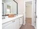 Bright bathroom vanity with double sinks and framed mirror overlooking a bedroom with neutral colors at 6450 Oak Valley Dr, Cumming, GA 30040