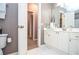 Neutral bathroom with white cabinets, vanity, white tile floors, and framed mirror at 6450 Oak Valley Dr, Cumming, GA 30040