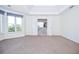 Large main bedroom featuring carpeting, tray ceiling, and view into bathroom with tub at 6450 Oak Valley Dr, Cumming, GA 30040