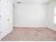 A view of a bedroom with neutral carpet and white walls, along with doors and a bright window at 6450 Oak Valley Dr, Cumming, GA 30040