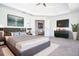 Staged main bedroom featuring a king bed, tray ceiling, and view into sitting area at 6450 Oak Valley Dr, Cumming, GA 30040