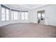 Bright main bedroom featuring carpeting, tray ceiling, and view into bathroom with tub at 6450 Oak Valley Dr, Cumming, GA 30040