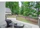 Picturesque deck with wood railing, wicker chairs, trees, rug and natural light at 6450 Oak Valley Dr, Cumming, GA 30040