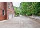 Long driveway leading to a three-car garage, surrounded by lush greenery and mature trees at 6450 Oak Valley Dr, Cumming, GA 30040
