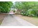 Charming brick home with a long driveway, lush landscaping, and a spacious front yard at 6450 Oak Valley Dr, Cumming, GA 30040