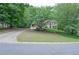 Traditional brick home featuring a manicured lawn and mature trees in a desirable neighborhood at 6450 Oak Valley Dr, Cumming, GA 30040