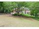 Brick home with a large front yard, mature trees, and established landscaping, set back from the street at 6450 Oak Valley Dr, Cumming, GA 30040