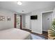 Bright bedroom with a view to the bathroom, hardwood floors, a bed and a mounted television at 1140 Allgood Rd, Stone Mountain, GA 30083